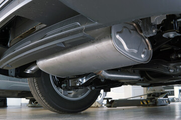 A muffler installed on a modern car. Bottom view of the car.