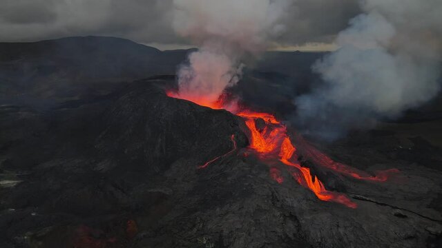 Aerial footage of an icelandic volcano erupting in 2021 in Reykjanes peninsula, shot at dusk with contrast with black lava landscape and red hot lava. High quality 4k footage