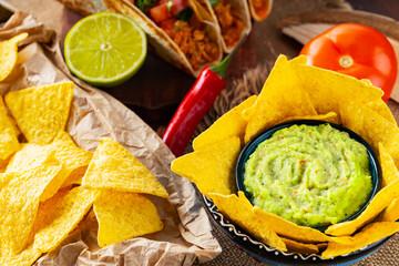 Mexican food table with nachos, guacamole, tacos and ingredients. Mexican taco and nacho tortilla...