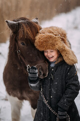 Walk on snow paths in winter among the reeds of the pony and the baby