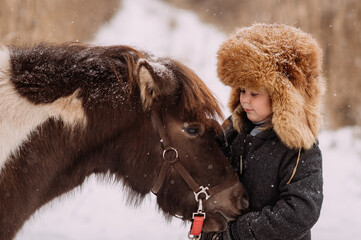 Walk on snow paths in winter among the reeds of the pony and the baby