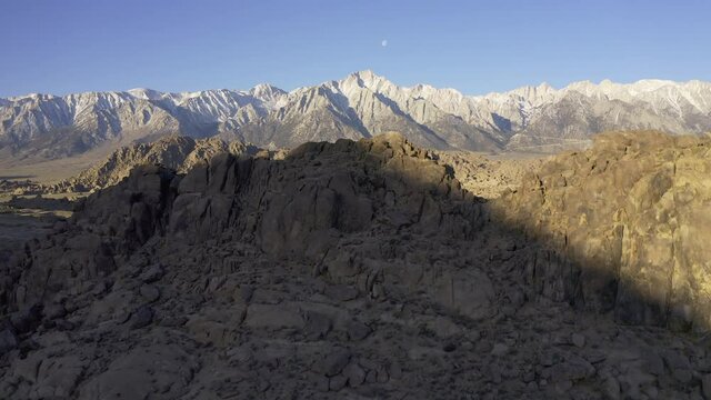A rising aerial reveal of the Alabama hills with snow capped peaks in the background.