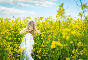 The girl is spinning among the blooming rapeseed