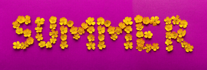 The SUMMER word laid out with the inflorescences of buttercups flowers. Creative yellow and purple floral background.