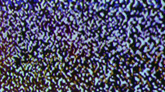 Close up view at a plasma tv while showing white noise .