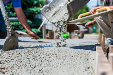 Workers make concrete trips. Trowel, shovel and other devices are used during work.