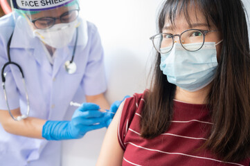 Asian woman while get a vaccine injection from doctor. Vaccination is one of the most effective ways to prevent virus.