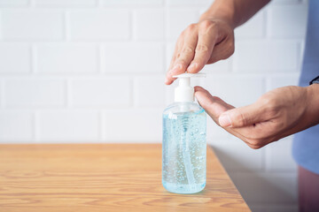 Asian businessman work from home self isolation in quarantine, stay safe with gel sanitizer cleaning hands protection from coronavirus covid-19 infection bacteria disease, living room at home