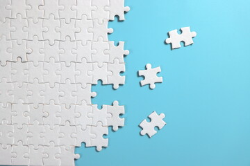 plain blue background with disassemble incomplete white jigsaw puzzle for your background or your content.