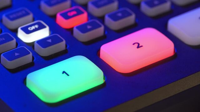 A close-up image of the video switcher shows alternating red and green lights on the buttons for cameras 1 and 2, indicating the operation of both cameras.