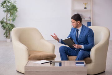 Young male employee waiting for business meeting