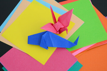 沢山の折り紙と、折り紙で折った鶴と魚。