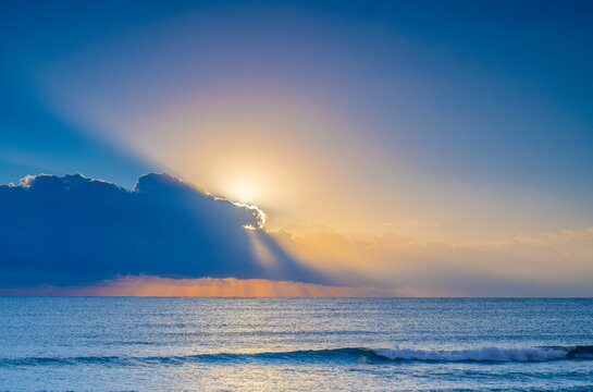 USA, Florida, Boca Raton, Sun rising behind clouds above sea