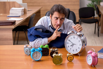 Young male employee sleeping in the office in time management co