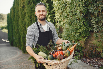 Portrait of smiling farmer holding vegetables basket