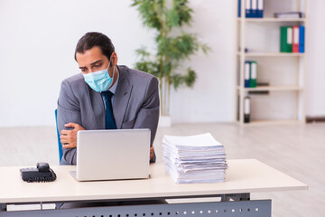 Young male employee wearing mask during pandemic