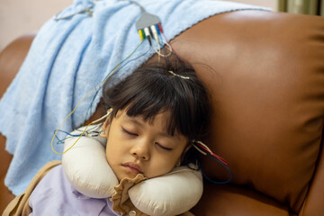 A little girl is sleeping and doing a neurofeedback exam. Making EEG electrodes.