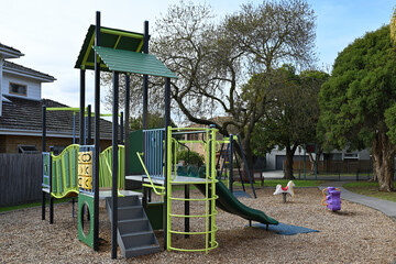 Unused play equipment in a playground, with a slide and tic-tac-toe games in the foreground, during...