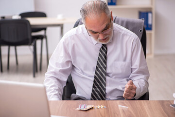 Aged male employee suffering at workplace