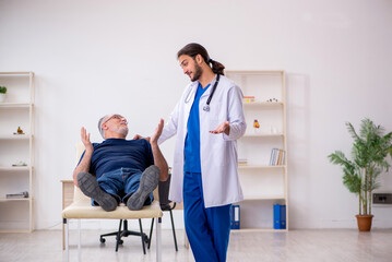 Old male patient visiting young male doctor chiropractor