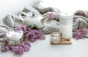 Spring home still life with a cup of milk and lilac flowers.