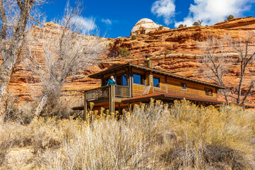 USA, Utah, Escalante, Woman on deck of home in canyon in Grand Staircase-Escalante National Monument