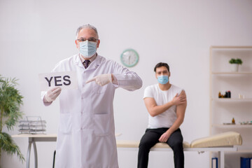 Young male patient visiting old male doctor in vaccination conce