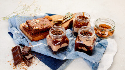 Trifles made with chocholate mousse and brownie on light gray background.