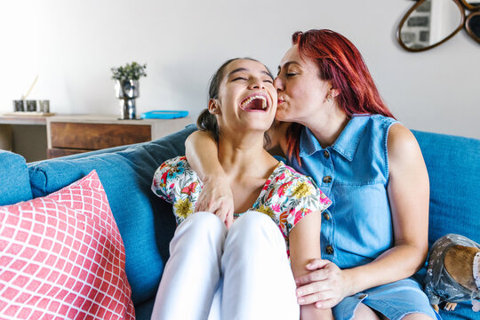 hispanic mother and her disabled daughter with cerebral palsy enjoying time together at home in disability concept in Latin America