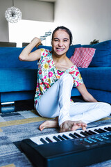 mexican disabled girl with cerebral palsy learning to play the piano with her foot at home in...