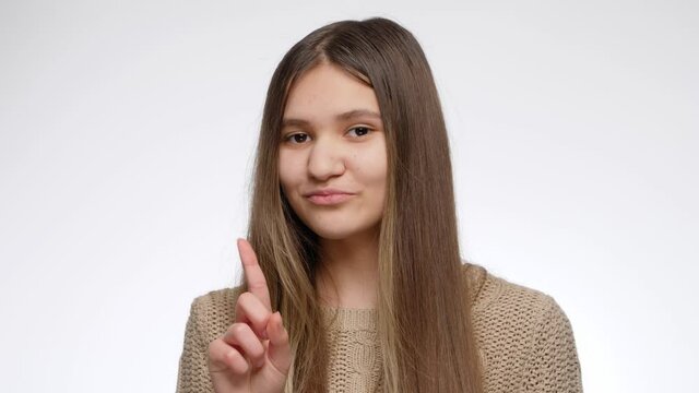 Portrait of smiling teenage girl shaking her head and showing no gesture with index finger