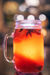 Close up of red drink non-alcoholic mulled wine with a straw on the background of the cafe interior, order for one