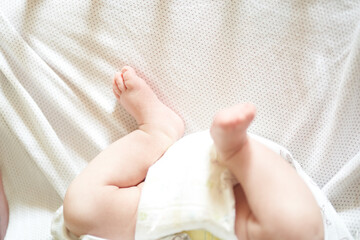 Baby legs on white sheet, newborn baby 1 month, care and love with copy space. High quality photo