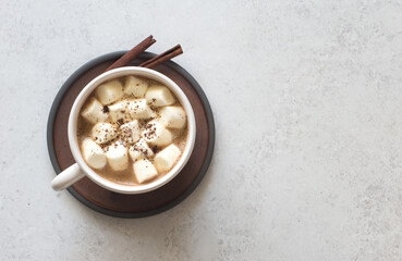 Cup of coffee and white marsmallows on gray stone background