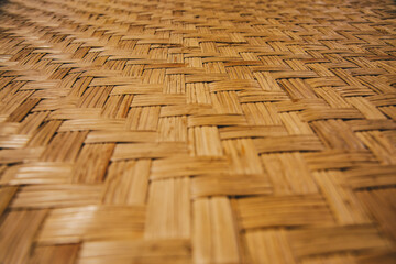 Close up Selective focus of texture Orange bamboo weave mat pattern in perspective view for...