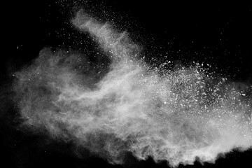 White powder explosion isolated on black background.White dust particles splash.