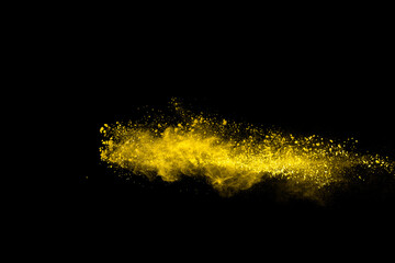 Yellow color powder explosion on black background.