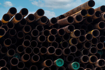Pile of old rusty round metal industrial pipe. Steel pipe stack at warehouse of factory. Industrial...