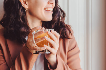 smiling woman drinking orange tea