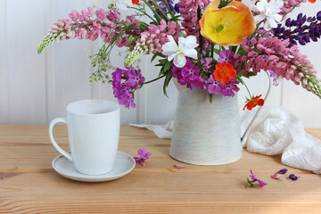 garden flowers in a jug and a white mug.