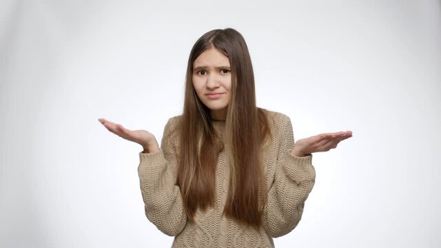 Amazed or confused girl showing wtf gesture over white studio background