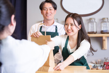 Naklejka premium テイクアウト商品を渡す男女 