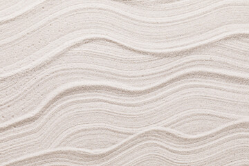 Wavy texture of light-colored sand, top view
