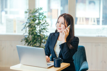 Obraz premium カフェで仕事するビジネスウーマン（笑顔） 