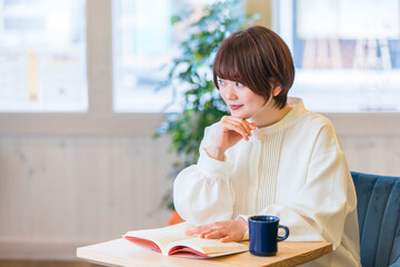 カフェで本を読む女性
