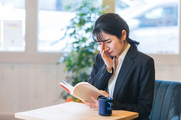カフェで本を読む女性（泣く）
