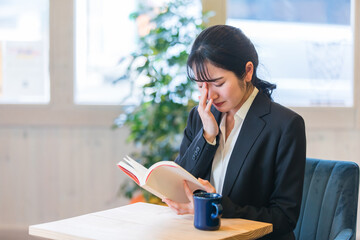 カフェで本を読む女性（泣く）
