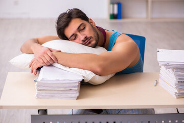 Young male employee coming to work straight from bed