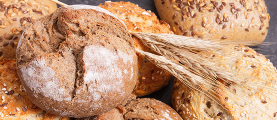 Wholegrain crunchy rolls for breakfast and ears of rye or wheat grain