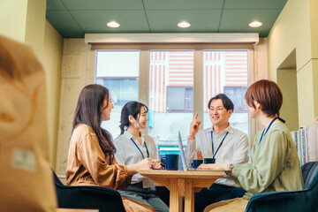 カフェ・オフィスで会議する会社員（爆笑・楽しい）
